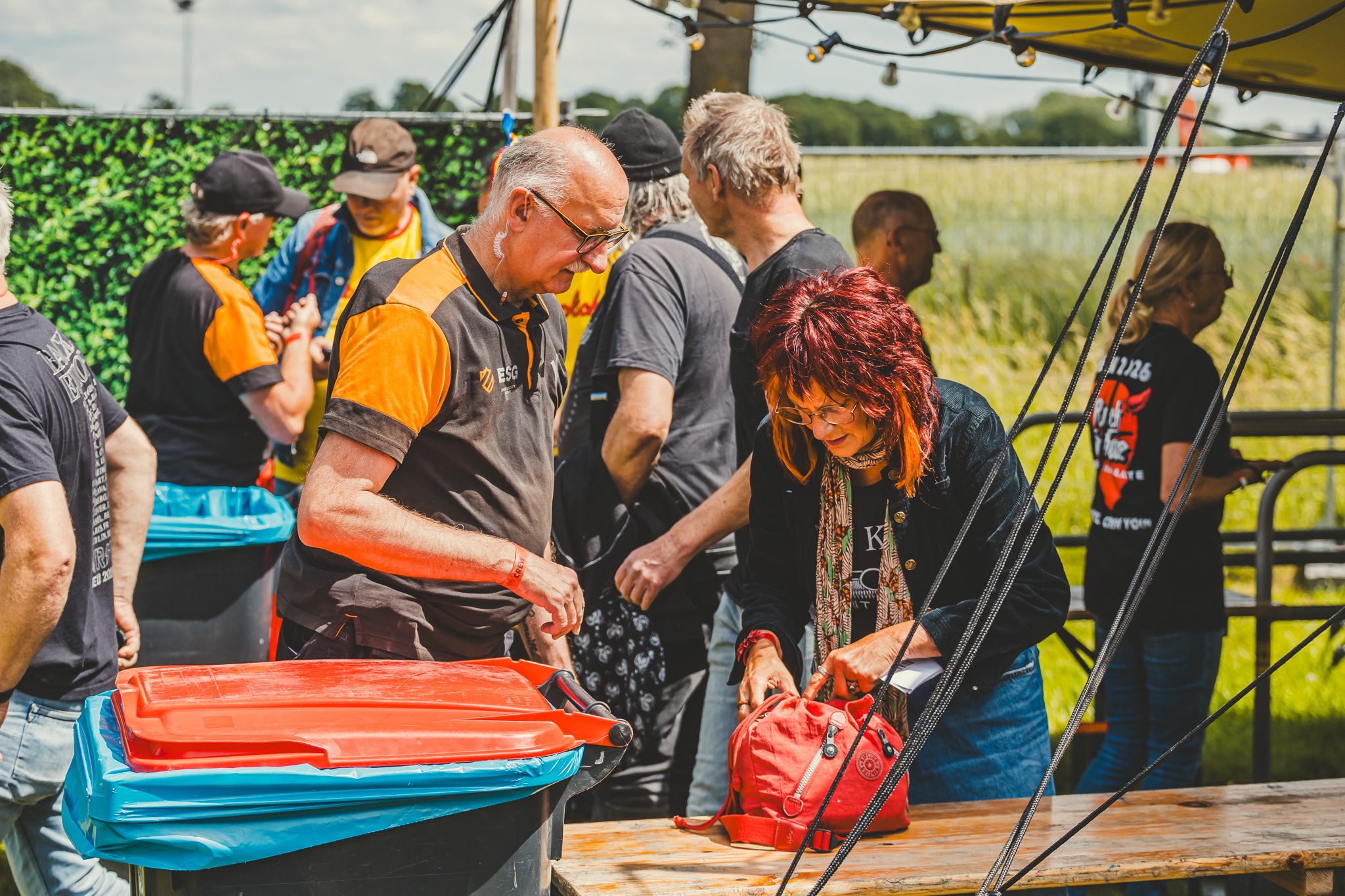 Een ESG-beveiliger helpt een bezoeker bij de controle aan de ingang
