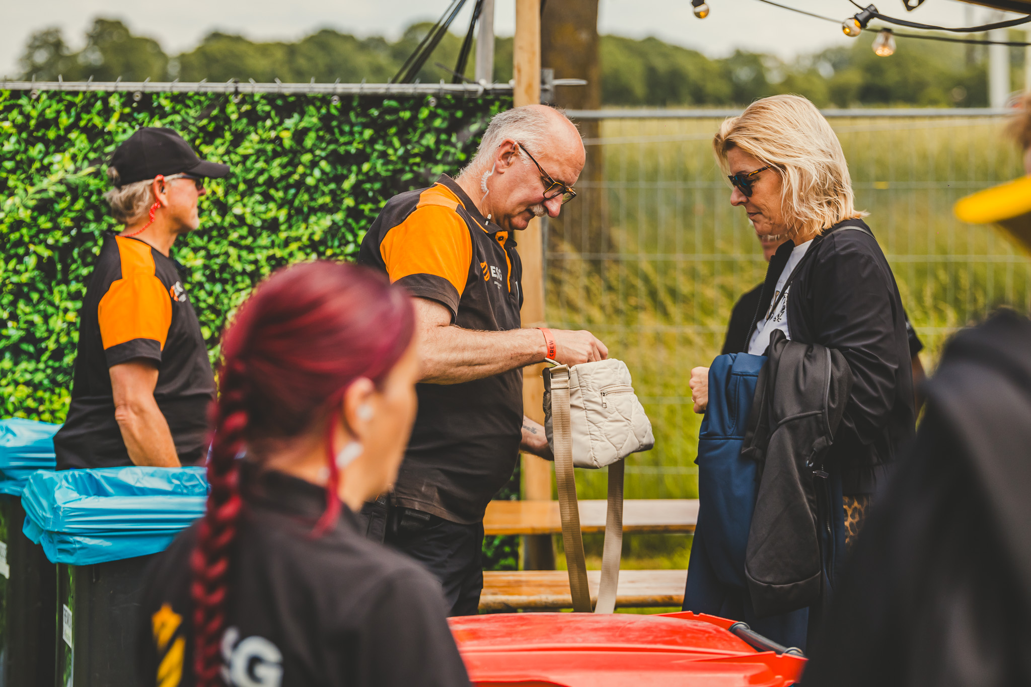 Een ESG-beveiliger controleert een tas bij de entree van een evenement